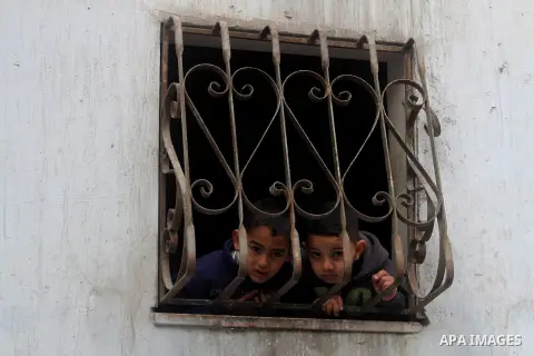 Palestinian children look through a window during the funeral of 15-year-old Waji al-Ramhi in the Jelazoun refugee camp in the West Bank city of Ramallah on December 8, 2013. Israeli troops shot dead Ramhi during early e...