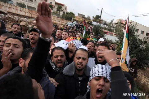 Mourners carry the body of 15-year-old Palestinian Waji al-Ramhi during his funeral in the Jelazoun refugee camp in the West Bank city of Ramallah on December 8, 2013. Israeli troops shot dead Ramhi during early evening...