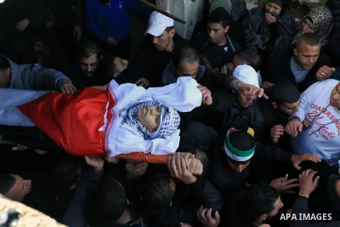 Mourners carry the body of 15-year-old Palestinian Waji al-Ramhi during his funeral in the Jelazoun refugee camp in the West Bank city of Ramallah on December 8, 2013. Israeli troops shot dead Ramhi during early evening...