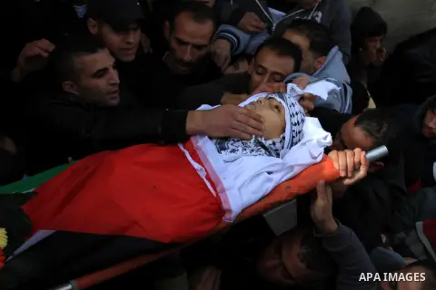 Mourners carry the body of 15-year-old Palestinian Waji al-Ramhi during his funeral in the Jelazoun refugee camp in the West Bank city of Ramallah on December 8, 2013. Israeli troops shot dead Ramhi during early evening...