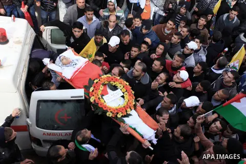 Mourners carry the body of 15-year-old Palestinian Waji al-Ramhi during his funeral in the Jelazoun refugee camp in the West Bank city of Ramallah on December 8, 2013. Israeli troops shot dead Ramhi during early evening...