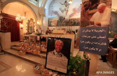 An image of the late South African leader President Nelson Mandela on display during a special Sunday service in his honour at the Holy Family Church in the West Bank city of Ramallah on December 8, 2013. Mandela, South...