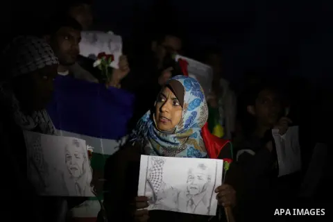 Palestinians hold portraits of late South African leader Nelson Mandela, during a candle vigil in Gaza City on December 8, 2013. Mandela, the revered icon of the anti-apartheid struggle in South Africa and one of the tow...