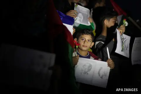 Palestinians hold portraits of late South African leader Nelson Mandela, during a candle vigil in Gaza City on December 8, 2013. Mandela, the revered icon of the anti-apartheid struggle in South Africa and one of the tow...