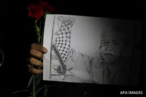 Palestinians hold portraits of late South African leader Nelson Mandela, during a candle vigil in Gaza City on December 8, 2013. Mandela, the revered icon of the anti-apartheid struggle in South Africa and one of the tow...