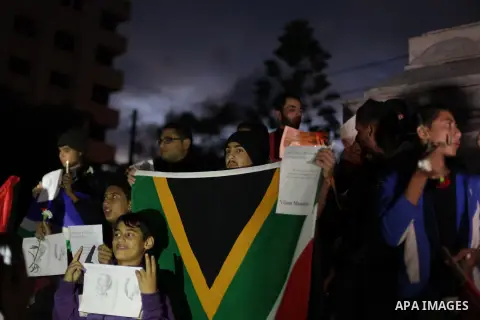 Palestinians hold portraits of late South African leader Nelson Mandela, during a candle vigil in Gaza City on December 8, 2013. Mandela, the revered icon of the anti-apartheid struggle in South Africa and one of the tow...