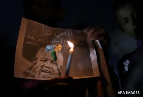 Palestinians hold portraits of late South African leader Nelson Mandela, during a candle vigil in Gaza City on December 8, 2013. Mandela, the revered icon of the anti-apartheid struggle in South Africa and one of the tow...