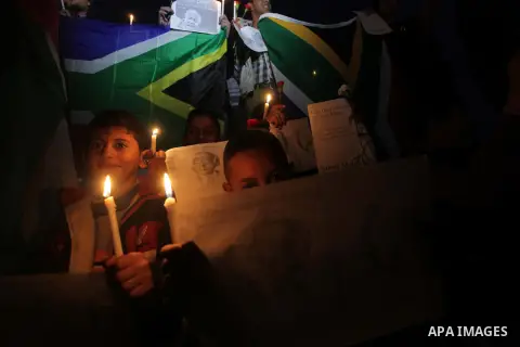 Palestinians hold portraits of late South African leader Nelson Mandela, during a candle vigil in Gaza City on December 8, 2013. Mandela, the revered icon of the anti-apartheid struggle in South Africa and one of the tow...