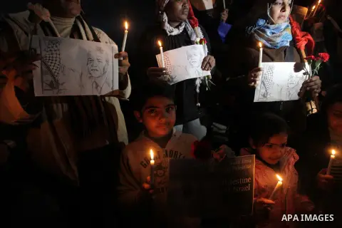 Palestinians hold portraits of late South African leader Nelson Mandela, during a candle vigil in Gaza City on December 8, 2013. Mandela, the revered icon of the anti-apartheid struggle in South Africa and one of the tow...