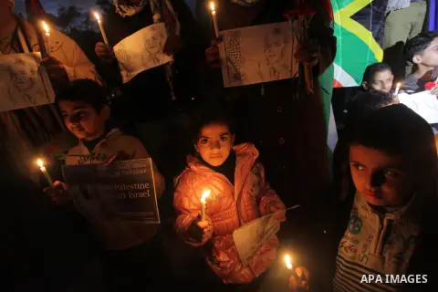 Palestinians hold portraits of late South African leader Nelson Mandela, during a candle vigil in Gaza City on December 8, 2013. Mandela, the revered icon of the anti-apartheid struggle in South Africa and one of the tow...