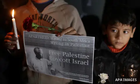 Palestinians hold portraits of late South African leader Nelson Mandela, during a candle vigil in Gaza City on December 8, 2013. Mandela, the revered icon of the anti-apartheid struggle in South Africa and one of the tow...