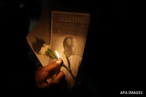 Palestinians hold portraits of late South African leader Nelson Mandela, during a candle vigil in Gaza City on December 8, 2013. Mandela, the revered icon of the anti-apartheid struggle in South Africa and one of the tow...