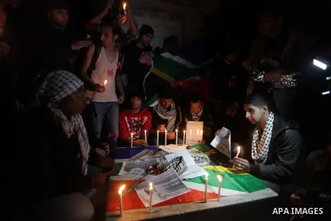 Palestinians put candles on a giant South African flag in the memory of late South African leader Nelson Mandela, during a candle vigil in Gaza City on December 8, 2013. Mandela, the revered icon of the anti-apartheid st...