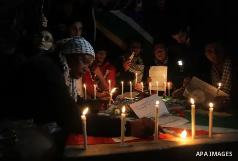 Palestinians put candles on a giant South African flag in the memory of late South African leader Nelson Mandela, during a candle vigil in Gaza City on December 8, 2013. Mandela, the revered icon of the anti-apartheid st...