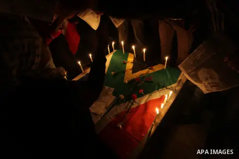 Palestinians put candles on a giant South African flag in the memory of late South African leader Nelson Mandela, during a candle vigil in Gaza City on December 8, 2013. Mandela, the revered icon of the anti-apartheid st...