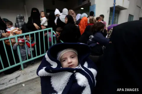 Palestinians wait in line to receive polio-vaccine during five days of an anti-polio campaign, in Gaza City on December 09, 2013. The Minister of Health in Gaza Strip, Mufid al-Mokhalalaty, said on Sunday that his minist...