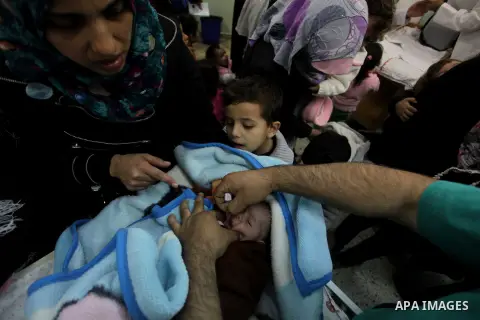 A Palestinian health worker administrates polio-vaccine drops to a child during five days of an anti-polio campaign, in Gaza City on December 09, 2013. The Minister of Health in Gaza Strip, Mufid al-Mokhalalaty, said on...