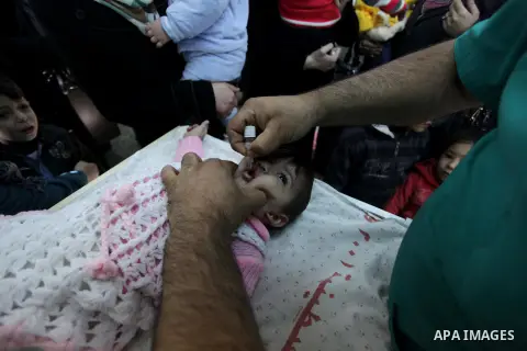 A Palestinian health worker administrates polio-vaccine drops to a child during five days of an anti-polio campaign, in Gaza City on December 09, 2013. The Minister of Health in Gaza Strip, Mufid al-Mokhalalaty, said on...
