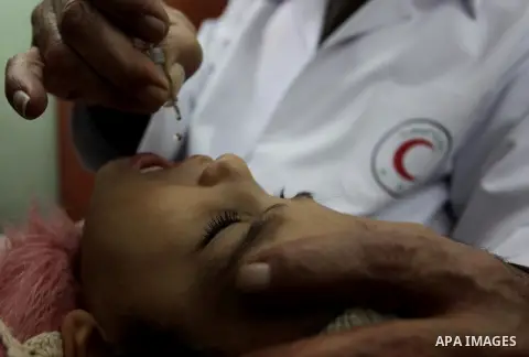 A Palestinian health worker administrates polio-vaccine drops to a child during five days of an anti-polio campaign, in Gaza City on December 09, 2013. The Minister of Health in Gaza Strip, Mufid al-Mokhalalaty, said on...