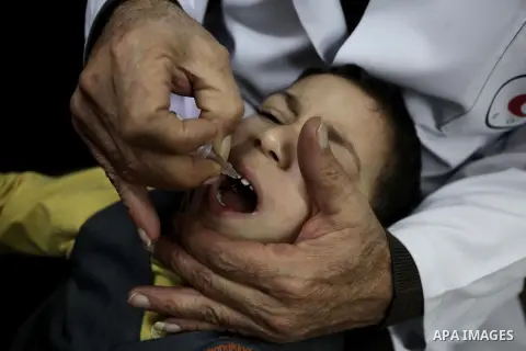 A Palestinian health worker administrates polio-vaccine drops to a child during five days of an anti-polio campaign, in Gaza City on December 09, 2013. The Minister of Health in Gaza Strip, Mufid al-Mokhalalaty, said on...