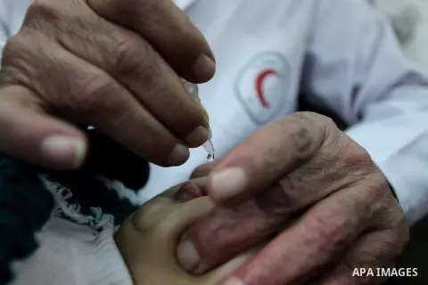 A Palestinian health worker administrates polio-vaccine drops to a child during five days of an anti-polio campaign, in Gaza City on December 09, 2013. The Minister of Health in Gaza Strip, Mufid al-Mokhalalaty, said on...