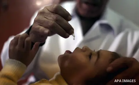 A Palestinian health worker administrates polio-vaccine drops to a child during five days of an anti-polio campaign, in Gaza City on December 09, 2013. The Minister of Health in Gaza Strip, Mufid al-Mokhalalaty, said on...