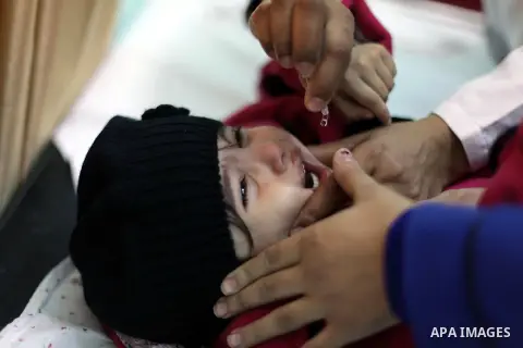 A Palestinian health worker administrates polio-vaccine drops to a child during five days of an anti-polio campaign, in Gaza City on December 09, 2013. The Minister of Health in Gaza Strip, Mufid al-Mokhalalaty, said on...