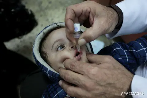 A Palestinian health worker administrates polio-vaccine drops to a child during five days of an anti-polio campaign, in Gaza City on December 09, 2013. The Minister of Health in Gaza Strip, Mufid al-Mokhalalaty, said on...
