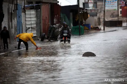 Palestinian civil defence try to drain out flooded water from a street during heavy rains on a stormy day in Gaza City, December 11, 2013. The Gaza Strip Power Authority is worried that electricity will be available for...