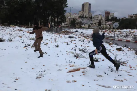 Palestinians enjoy a snowball fight during snowy weather in the West Bank city of Ramallah, 12 December 2013. The West Bank was affected by a snowstorm over the weekend, hitting Nablus, Ramallah and Jerusalem. Palestinia...