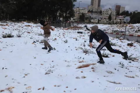 Palestinians enjoy a snowball fight during snowy weather in the West Bank city of Ramallah, 12 December 2013. The West Bank was affected by a snowstorm over the weekend, hitting Nablus, Ramallah and Jerusalem. Palestinia...