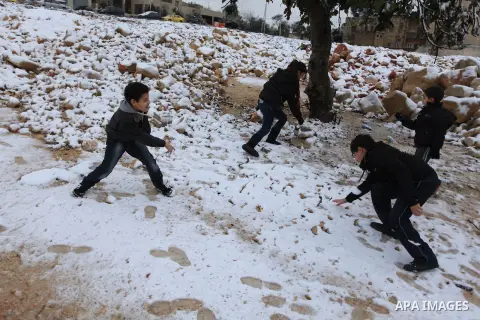 Palestinians enjoy a snowball fight during snowy weather in the West Bank city of Ramallah, 12 December 2013. The West Bank was affected by a snowstorm over the weekend, hitting Nablus, Ramallah and Jerusalem. Palestinia...