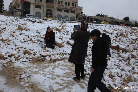 Palestinians enjoy a snowball fight during snowy weather in the West Bank city of Ramallah, 12 December 2013. The West Bank was affected by a snowstorm over the weekend, hitting Nablus, Ramallah and Jerusalem. Palestinia...