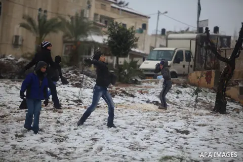 Palestinians enjoy a snowball fight during snowy weather in the West Bank city of Ramallah, 12 December 2013. The West Bank was affected by a snowstorm over the weekend, hitting Nablus, Ramallah and Jerusalem. Palestinia...