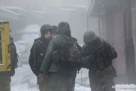 Israeli soldiers guard the Israeli barrier despite of the snow in the West Bank city of Hebron,12 December 2013. The West Bank was affected by a snowstorm over the weekend, hitting Nablus, Ramallah and Jerusalem. Palesti...