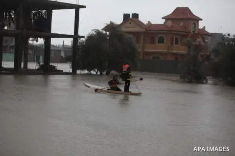 Members of the Palestinian civil defense ride a boat in a flooded street following heavy rains on a stormy day in Rafah, in the southern Gaza Strip, December 12, 2013. Streets in Gaza are flooded after only three hours o...