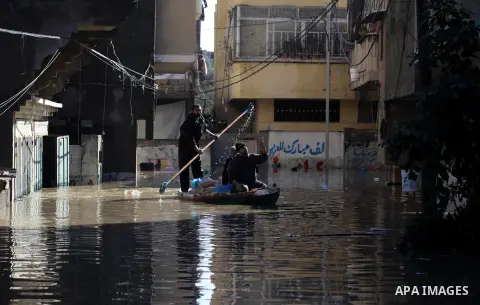 Palestinian civil defense volunteers deliver the aids to the people at their flooded house in Gaza City following rain storms for the past few days, on December 15, 2013. More than 5,000 people have been evacuated from f...