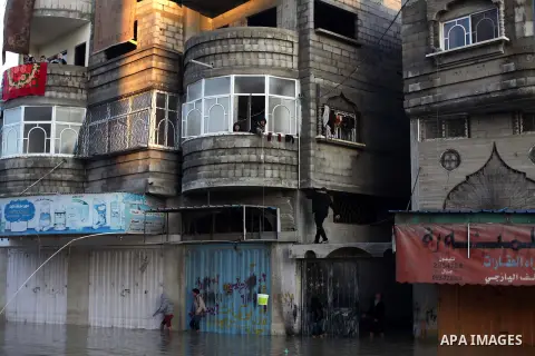 Palestinian civil defense volunteers deliver the aids to the people at their flooded house in Gaza City following rain storms for the past few days, on December 15, 2013. More than 5,000 people have been evacuated from f...