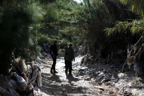 Palestinians walk next to their houses after flooded during four days of storms in Deir al-Balah in central Gaza Strip, December 17, 2013. A fierce winter storm shut down much of the Middle East last week leaving people...
