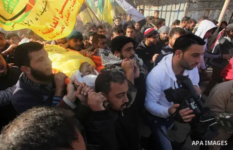 Palestinian mourners carry the body of 22-year-old Palestinian Odah Hamad during his funeral in Beit Hanoun in the northern Gaza Strip December 21, 2013. Israeli forces shot and killed a Palestinian, Hamad, and wounded t...