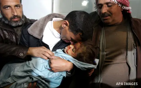 A Palestinian relative carries the lifeless body of 3-year-old Hala Abu Sebakha, who medics said was killed by shrapnel during an Israeli air strike on the Al Maghazi camp, at the morgue of Al-Aqsa hospital in Deir Al Ba...