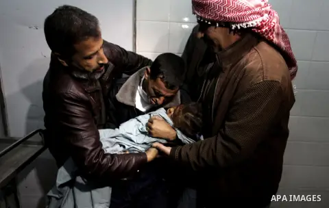 A Palestinian relative carries the lifeless body of 3-year-old Hala Abu Sebakha, who medics said was killed by shrapnel during an Israeli air strike on the Al Maghazi camp, at the morgue of Al-Aqsa hospital in Deir Al Ba...