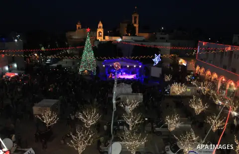 Christians take part in the Christmas celebrations outside the Church of the Nativity in the West Bank city of Bethlehem, on December 24, 2013. Thousands of Palestinians and tourists flocked into the West Bank city of Be...