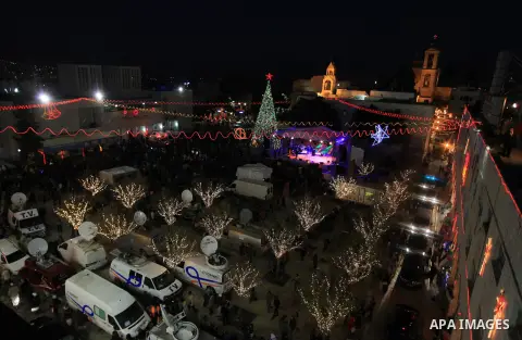 Christians take part in the Christmas celebrations outside the Church of the Nativity in the West Bank city of Bethlehem, on December 24, 2013. Thousands of Palestinians and tourists flocked into the West Bank city of Be...