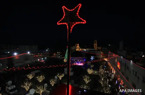 Christians take part in the Christmas celebrations outside the Church of the Nativity in the West Bank city of Bethlehem, on December 24, 2013. Thousands of Palestinians and tourists flocked into the West Bank city of Be...