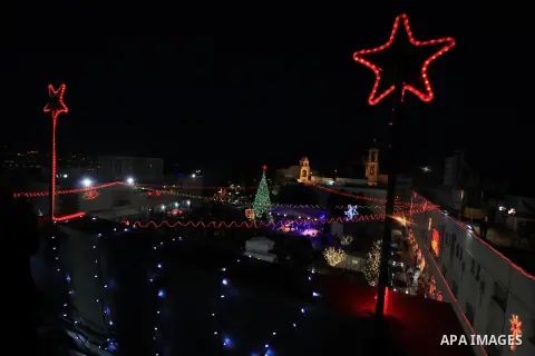 Christians take part in the Christmas celebrations outside the Church of the Nativity in the West Bank city of Bethlehem, on December 24, 2013. Thousands of Palestinians and tourists flocked into the West Bank city of Be...