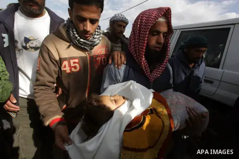 A relative carries the body of three-year-old Hala Abu Sabakha during her funeral in the central of Gaza Strip, on December 25, 2013. Sabikha was killed and at least six other people wounded in a series of Israeli air an...