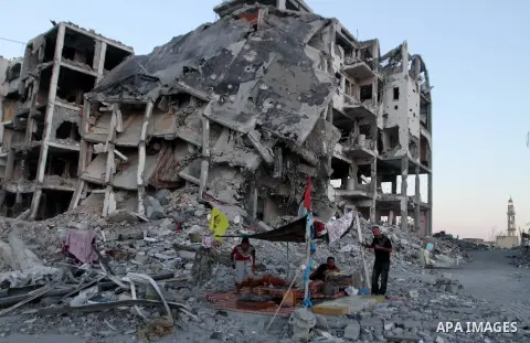 Palestinians sit in a tent outside houses, which witnesses said were destroyed in an Israeli offensive, during a 72-hour truce in Beit Lahiya town in the northern Gaza Strip August 12, 2014. Talks to end a month-long war...