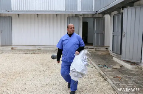 An employee of the Palestinian Ministry of Health wearing a mask prepares the a quarantine place to test passengers returning from China for coronavirus, installed by Palestinian ministry of health, at Rafah border cross...