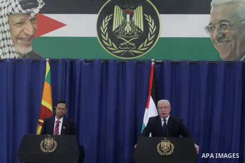 Sri Lanka's foreign minister Gamini Peiris, left, with his Palestinian counterpart Riad al-Malki during a joint press conference in the West Bank city of Ramallah, Monday, Jan. 6, 2014. Portraits of the late Palestinian...